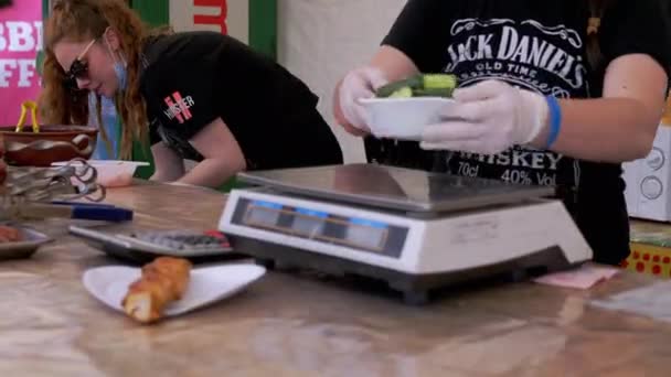 Gatuförsäljare väger sallad från gurkor i lunchlådan på elektroniska vågar — Stockvideo