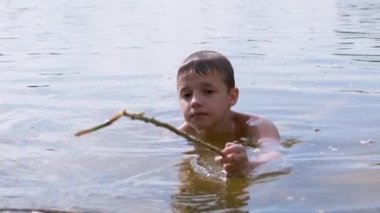 Aktif Çocuk Nehirde Bir Sopayla Oynuyor, Su Dalgaları Yaratıyor, Su Sıçratıyor