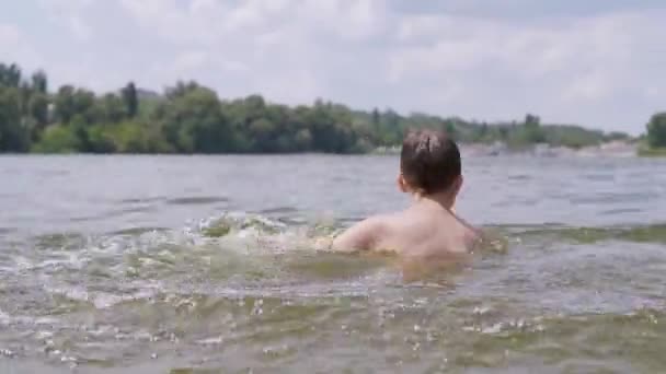 Child Splashes in the Water, the River, Creating Waves, Splashes, Whirlpools. 4K — Vídeo de Stock