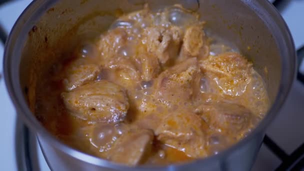 Kook gestoofde stukken sappig kippenvlees in een pan op een gasfornuis — Stockvideo