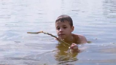 Aktif Çocuk Nehirde Bir Sopayla Oynuyor, Su Dalgaları Yaratıyor, Su Sıçratıyor