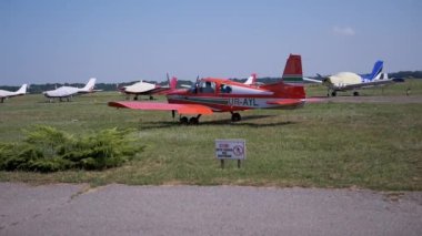 Küçük bir eğitmen uçağının inişi, pervaneli uçak pistte.