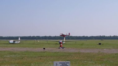 Küçük bir eğitmen uçağının inişi, pervaneli uçak pistte.