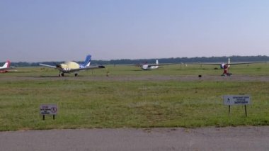 Küçük bir eğitmen uçağının inişi, pervaneli uçak pistte.