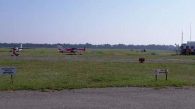 Küçük bir eğitmen uçağının inişi, pervaneli uçak pistte.