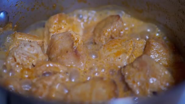 Hervir trozos de carne de pollo jugosa en una cacerola en una estufa de gas — Vídeo de stock