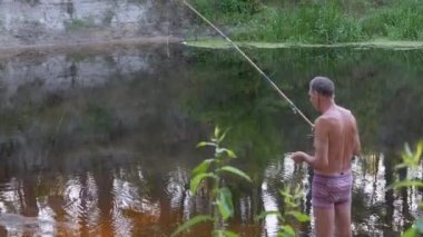 Balıkçı Güneş Işıkları 'nda Sessiz Nehir' in yanında Balık Yakalıyor. 4K
