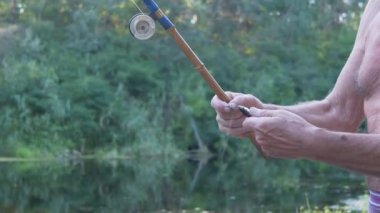 Balıkçı kancadan Eski Bambu Oltayla Yakaladığı Küçük Balığı Alıyor