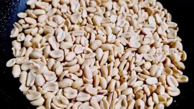 Kabuklu ve siyah desenli bir tavayı dolduran fındıklı makro tepeden tırnağa görüntü. Statik çekim, baklagillerin dokusunu ve detaylarını yemek pişirmek ya da sağlıklı bir atıştırmalık olarak vurgular..