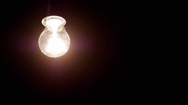 Parlak bir cam aydınlatma armatürü çevredeki karanlığa sıcak ve davetkar bir parıltı yayar ve atmosferi güçlendirir.