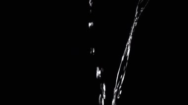 Two Streams of Water with Drops Pour into Empty Space. Black background. A transparent stream of water with streams joins into a funnel. Splashes, drops. Abstraction, texture, lighting. Slow motion.