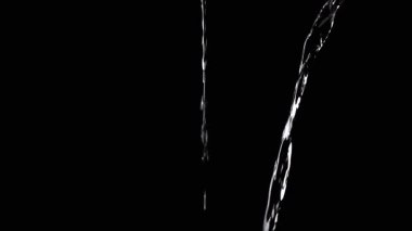 Two Streams of Water with Drops Pour into Empty Space. Black background. A transparent stream of water with streams joins into a funnel. Splashes, drops. Abstraction, texture, lighting. Slow motion.