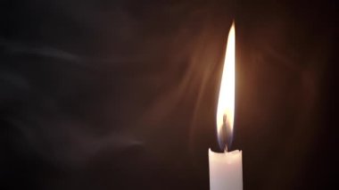 Burning Wax Candle in Cloud of Thick Smoke on Black Background. Puffs of thick smoke fill empty space with burning candle. Abstract, isolated. Blurred motion. Soft texture, structure of smoke or steam.