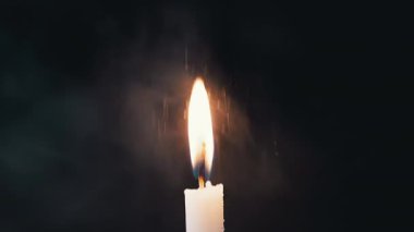 Mum alevinin büyüleyici güzelliğini keşfedin. Yavaşça yanıp sönen, siyah bir zemin üzerinde ışıldayan, kar tanecikleri düşerek huzurlu görüntüler yaratmak için mükemmel. Yavaş çekim.