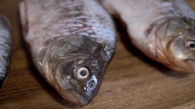 Ahşap bir yüzeye ustalıkla dizilmiş taze balığın yakın çekim görüntüsü, hem yemek pişirme hem de piyasa gösterisi için mükemmel.