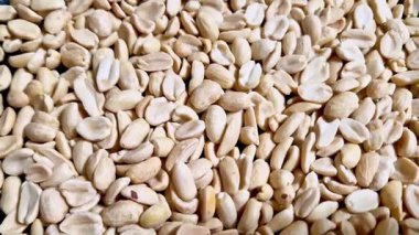 Kavrulmuş ve kabuklu fıstıklı büyük bir yığın makro yakın çekim. Bej fındıkların dokulu yüzeyi, aşçılık veya beslenme temalı içerik için ayrıntılı bir besin arkaplanı sağlar.