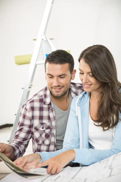 Couple in new home choosing wall paint colors — Stock Photo, Image