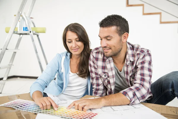 Pareja en el nuevo hogar elegir colores de pintura de pared —  Fotos de Stock