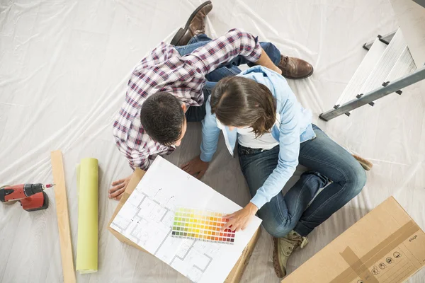 Pareja en el nuevo hogar elegir colores de pintura de pared —  Fotos de Stock