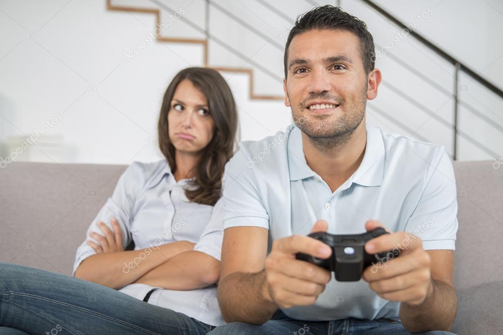 Man disappointed while playing video game with girlfriend at home stock  photo