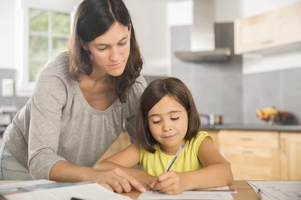 Mãe e filha fazendo lição de casa juntos. — Fotografia de Stock