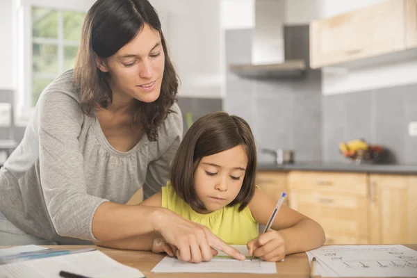 Mãe e filha fazendo lição de casa juntos. — Fotografia de Stock