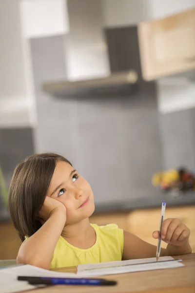 Portrait of little girl doing homework ar table — Stock Photo, Image