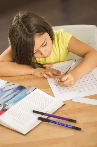 Portret van meisje doet huiswerk ar tabel — Stockfoto