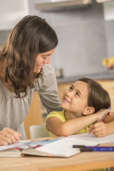Mother and daughter doing homework together. — Stock Photo, Image