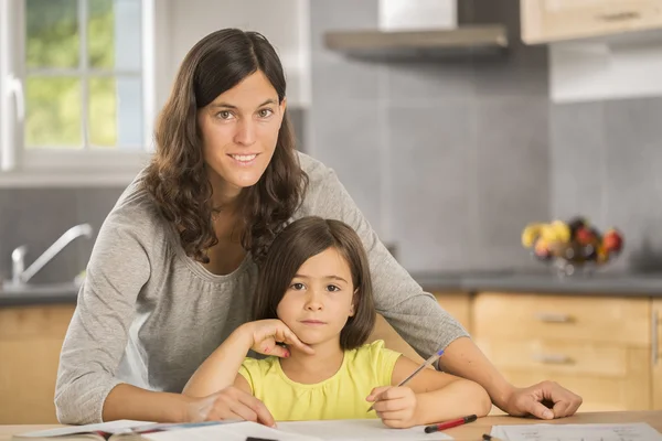 Mãe e filha fazendo lição de casa juntos. — Fotografia de Stock