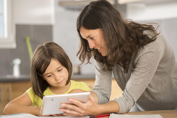 Мати і дочка роблять домашнє завдання з планшетом — стокове фото