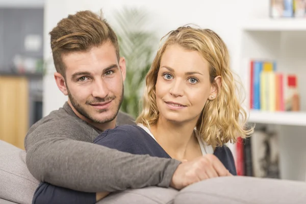 Pareja alegre relajándose en el sofá en casa — Foto de Stock