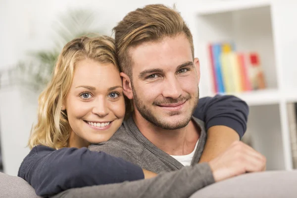 Cheerful couple relaxing in sofa at home — Stock Photo, Image