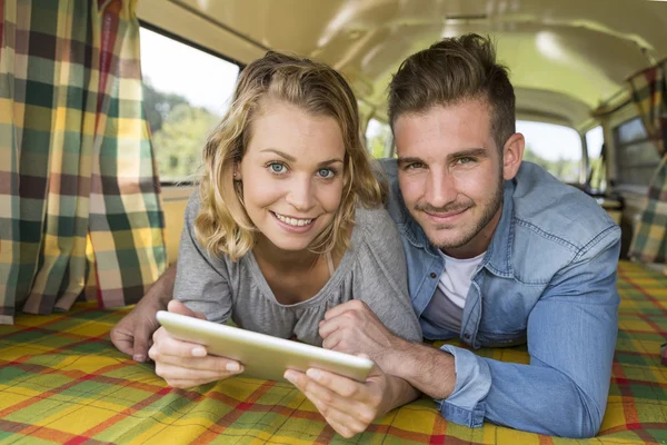 Joven pareja con vintage caravana utilizando touchpad — Foto de Stock