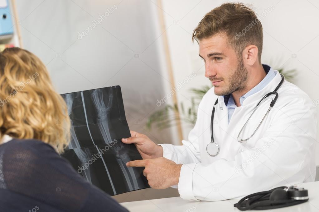 Surgeon showing X-ray to patient in medical office