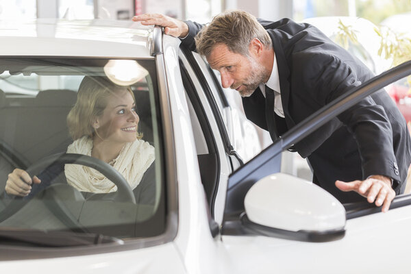 Car dealer showing vehicle binnacle to clients