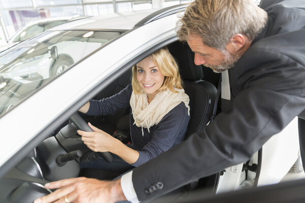 Car dealer showing vehicle binnacle to clients