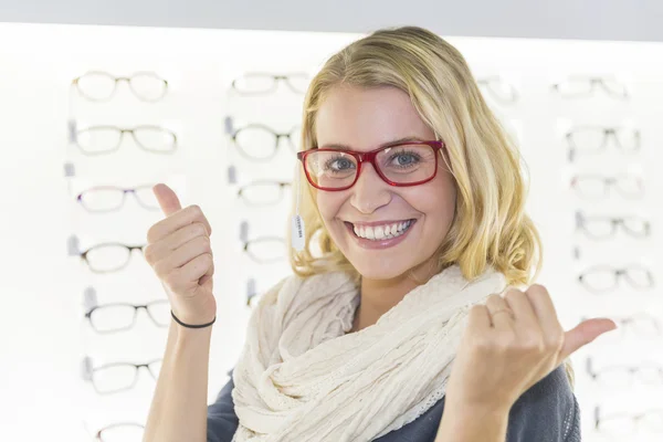 Woman in optical center trying eyeglasses on