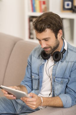 genç adam listenig müzik dijital tablet vasıl ev ile