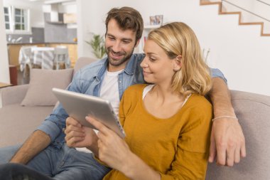 Evde dijital tablet kullanan genç çift