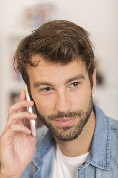 Mladý muž mluví po telefonu doma — Stock fotografie