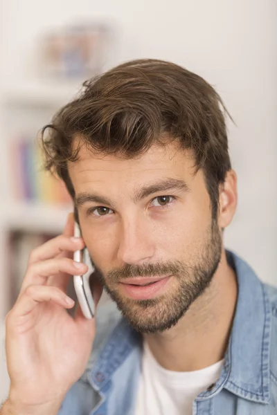 Unge man pratar i telefon hemma — Stockfoto