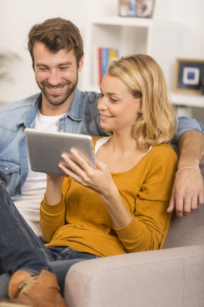 Young couple using digital tablet at home — Stock Photo, Image