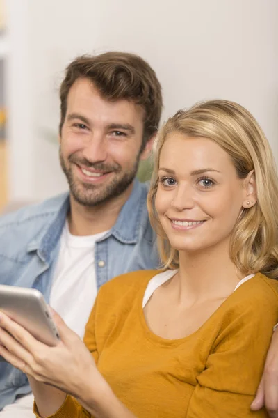 Jovem casal usando tablet digital em casa — Fotografia de Stock