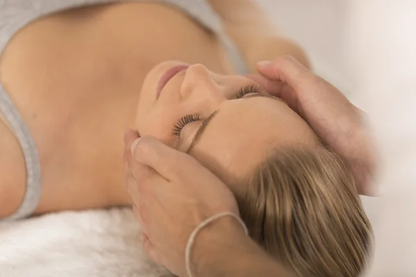 Masajista haciendo masaje la cabeza de una mujer en el salón de spa — Foto de Stock