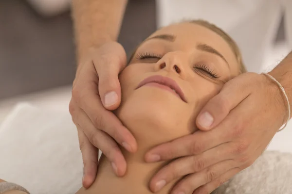 Masajista haciendo masaje la cabeza de una mujer en el salón de spa — Foto de Stock