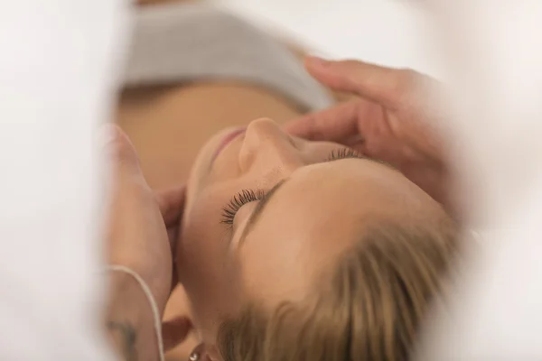 Masajista haciendo masaje la cabeza de una mujer en el salón de spa —  Fotos de Stock