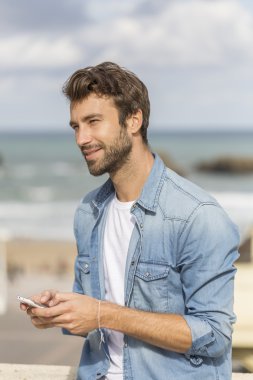 Genç adam akıllı telefon kullanıyor. 