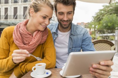 Genç çift dijital tablet bir barda kullanma Teras
