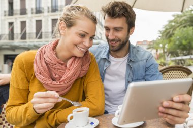Genç çift dijital tablet bir barda kullanma Teras